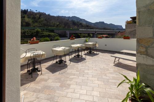 a patio with tables and chairs on a balcony at Beb Diavolo Furbetto in Orco Feglino