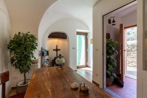a dining room with a wooden table and a cross on the wall at Beb Diavolo Furbetto in Orco Feglino