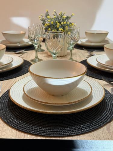 a table with a bowl and plates and wine glasses at Camelia - 3 Bedroom Maisonnette with terrace and Seaviews - Bugibba in St Paul's Bay