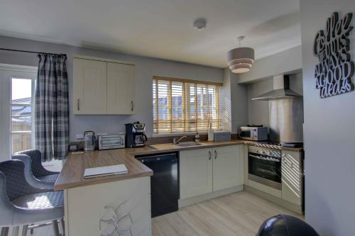 a kitchen with white cabinets and a counter top at 3 Mackay Road, Dornoch in Dornoch