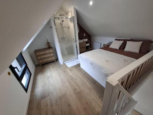 un dormitorio en el ático con una cama y una escalera en Ty C&K Breizh, en Plerguer