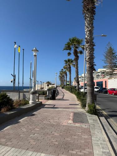 a sidewalk with palm trees on the side of a street at Camelia - 3 Bedroom Maisonnette with terrace and Seaviews - Bugibba in St Paul's Bay
