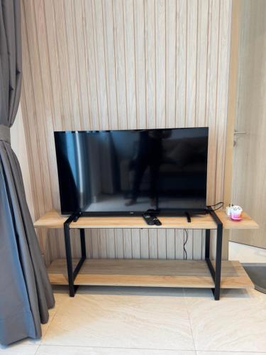 a flat screen tv sitting on top of a tv stand at The Luxe KLCC by Homestay in Kuala Lumpur