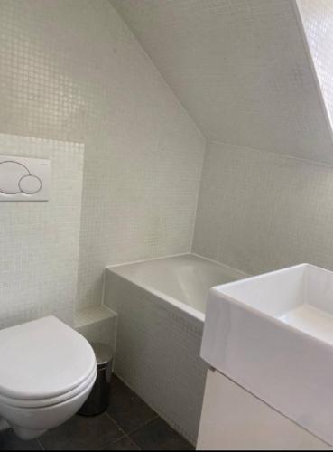 une salle de bain blanche avec des toilettes et un lavabo dans l'établissement Charmant studio Montparnasse, à Paris