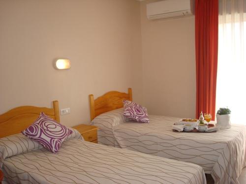 a bedroom with two beds with pillows on them at Hotel Fin De Semana in Gandía