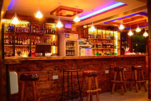 a bar with bar stools in a room with alcohol at Bunyonyi Safaris Resort in Kabale
