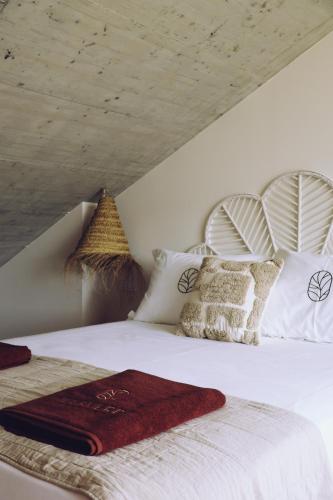 a bedroom with a bed with white sheets and pillows at Villaverde Village in Santillana del Mar