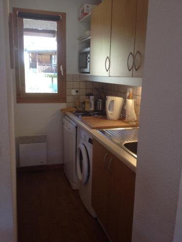 une cuisine avec un évier et une machine à laver dans l'établissement Chalet duplex Parc Aux Etoiles 1800, à Puy-Saint-Vincent