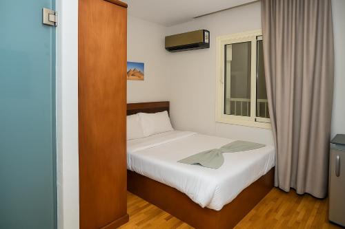 a small bedroom with a bed and a window at Miramar Green Talaat harb in Cairo