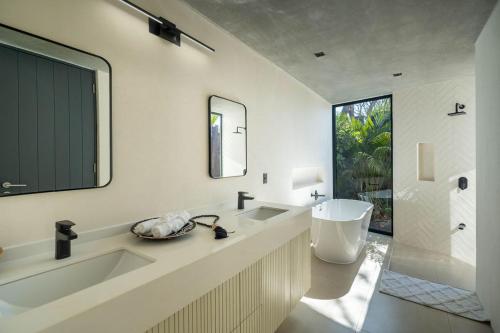 Un baño con bañera, lavabo y espejo. en Casa Avellanas, en Playa Avellana