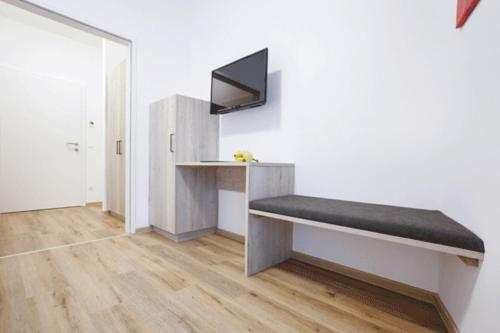 una stanza con una panca e una scrivania di TPE Arena - Zimmer am Ebersdorfer See a Obergrafendorf