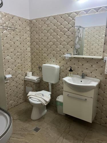 a bathroom with a white toilet and a sink at Pensiunea Apuseni Boga in Boga