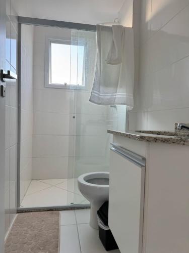 a white bathroom with a shower and a toilet at Aruana - Diamante in Aracaju