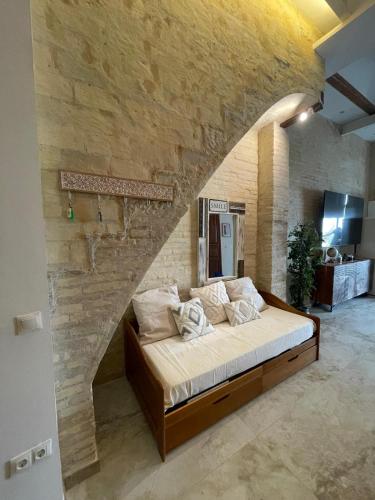 a bedroom with a large bed in a stone wall at Dream Big with jacuzzi and terrace in Ruzafa in Valencia