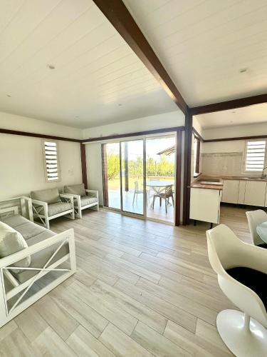 a living room filled with furniture and a table at Villa " Une Histoire", votre havre de paix à deux pas de la plage in Sainte-Rose