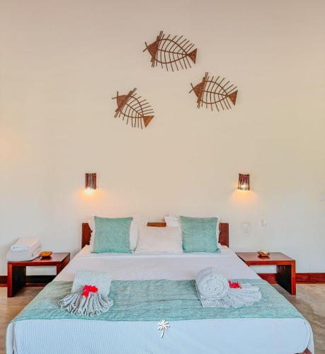 a bedroom with a bed with three fish on the wall at Villa Guaiuba linda casa com piscina e vista por mar ! in Icaraí