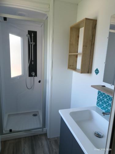 une salle de bain avec douche et lavabo dans l'établissement Camping SIBLU les sables du midi, à Valras-Plage