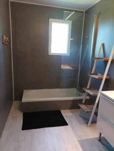 une salle de bain avec une baignoire et une fenêtre dans l'établissement A la campagne - détente -piscine, à Laboutarié