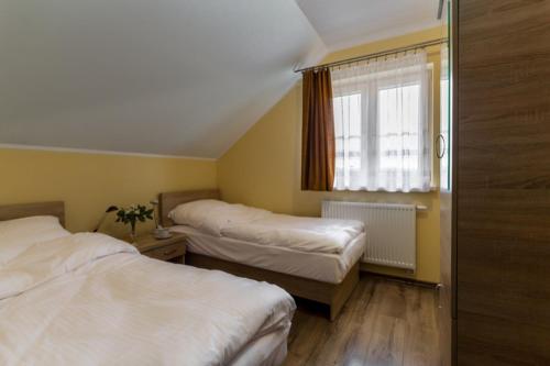 a bedroom with two beds and a window at 4 Pory Roku in Polańczyk