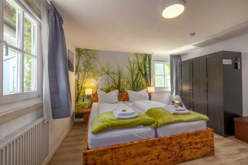 a bedroom with a large bed with a green blanket on it at Landgasthof Zum Dorfkrug in Schöneberg