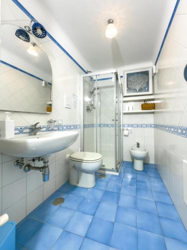 a blue and white bathroom with a toilet and a sink at Maison MariClà by NDP rent in Anacapri