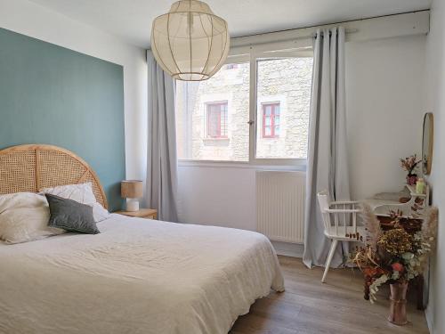 une chambre avec un lit blanc et une fenêtre dans l'établissement les Clés du lys, à Périgueux