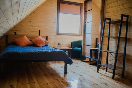 a bedroom with a bed with blue sheets and a ladder at Hawiry Nad Dylą in Głębockie Pierwsze