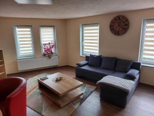 a living room with a blue couch and a coffee table at Waldquelle in Plauen