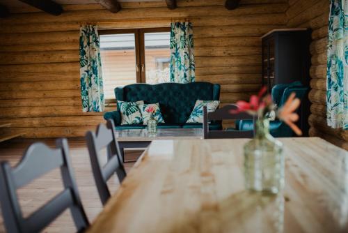 a dining room with a table and a couch at Hawiry Nad Dylą in Głębockie Pierwsze