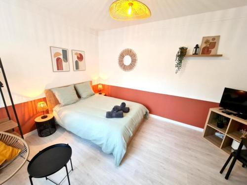 a bedroom with a bed with a teddy bear on it at L'Europa - Gare - Centre - Wifi in Arras