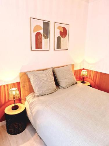 a bedroom with a white bed with two lamps at L'Europa - Gare - Centre - Wifi in Arras