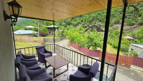 a balcony with blue chairs and a table and a view at Hotel Bakuna in Gulida