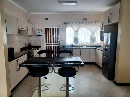 a kitchen with a table and chairs in it at Ivy Cottage in Harare
