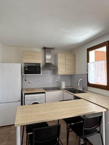 Il comprend une cuisine équipée d'un réfrigérateur blanc et d'une table en bois. dans l'établissement Mazet climatisé avec piscine & tennis Résidence calme proche Lavandou, à Bormes-les-Mimosas