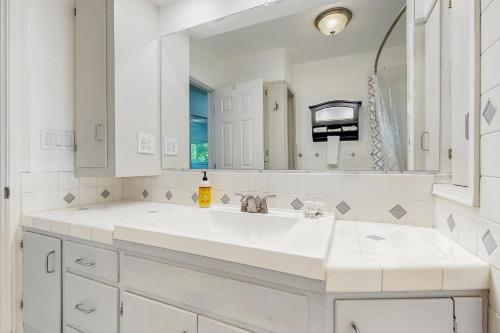 Un baño blanco con lavabo y espejo. en Historic SW Portland Sanctuary, en Portland