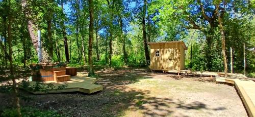 une maison extérieure en bois au milieu d'une forêt dans l'établissement Tente Lodge, à Saint-Paul-en-Born