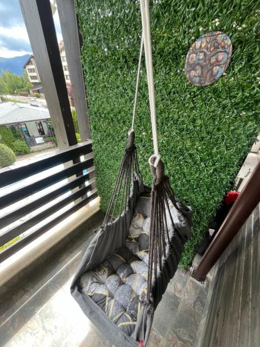 a hammock hanging on a porch next to a window at Aspen Suites Студио Слънчев ден in Razlog