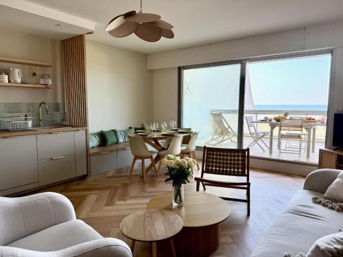 - un salon avec une table et une cuisine avec vue dans l'établissement Les Iles Bauloises, à La Baule