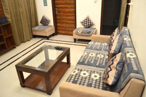 a living room with two couches and a glass table at Ananta Square - Rishikesh 1BHK in Rishīkesh