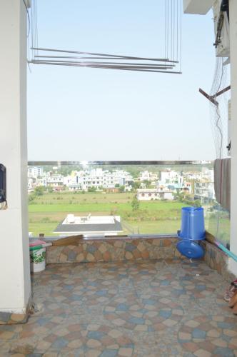 a room with a window with a view of a city at Ananta Square - Rishikesh 1BHK in Rishīkesh