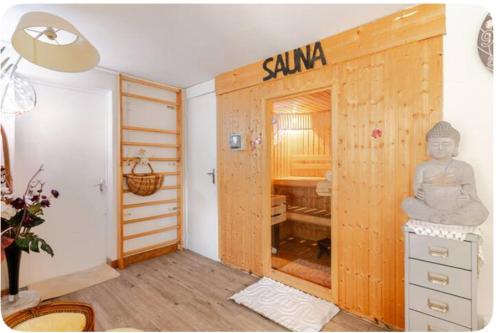 una stanza con una porta con una statua di Buddha su di essa di Gîte 1 à 6 personnes Rez de jardin de la villa piscine et sauna à partager Jacuzzi en option a Sarlat-la-Canéda