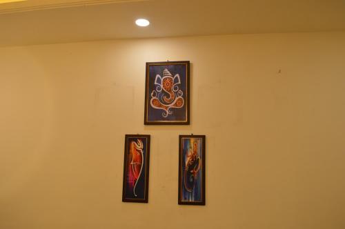 four framed paintings on a wall in a room at Ananta Square - Rishikesh 1BHK in Rishīkesh