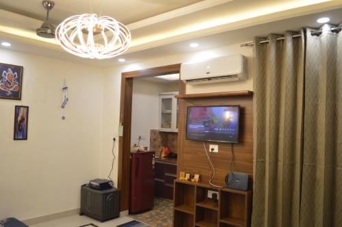 a living room with a tv and a curtain at Ananta Square - Rishikesh 1BHK in Rishīkesh