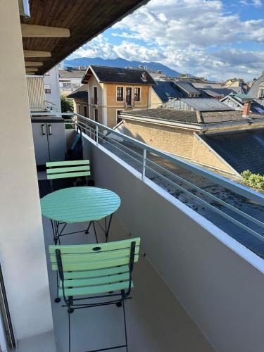 d'une table et de chaises vertes sur un balcon avec vue. dans l'établissement L'Isaline, à Aix-les-Bains