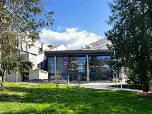 un grand bâtiment en verre avec un panneau. dans l'établissement L'Isaline, à Aix-les-Bains