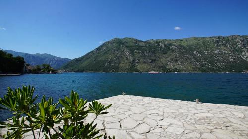 a view of a large body of water with a mountain at PENTHOUSE STOLIV Villa located 5 meters from the sea SPA-Pool Exclusive Terrace,Private Jetty Sunbeds, Pebble Beach, Secluded location Total area 375m2 at your disposal in Kotor