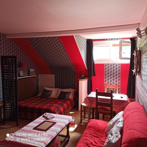 une chambre avec deux lits et un mur rouge dans l'établissement PETIT APPARTEMENT 30M2, 3 lits, de 1 à 4 pers, à Neuilly