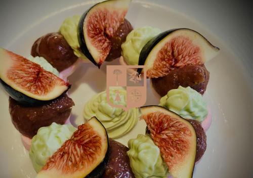 a white plate with blood figs and cream on it at Moulin Lombard B&B in Les Arcs sur Argens