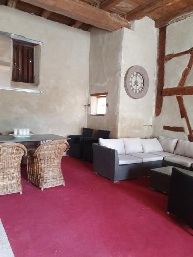 a living room with a couch and a table and chairs at Domaine d'Alémanie in Ebersmunster