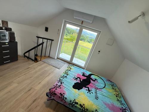 a bedroom with a bed and a large window at Słoneczny domek 